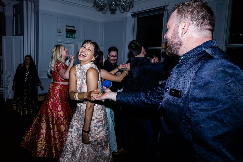 a Hindu bride laughs as she and her groom dance at their wedding. 