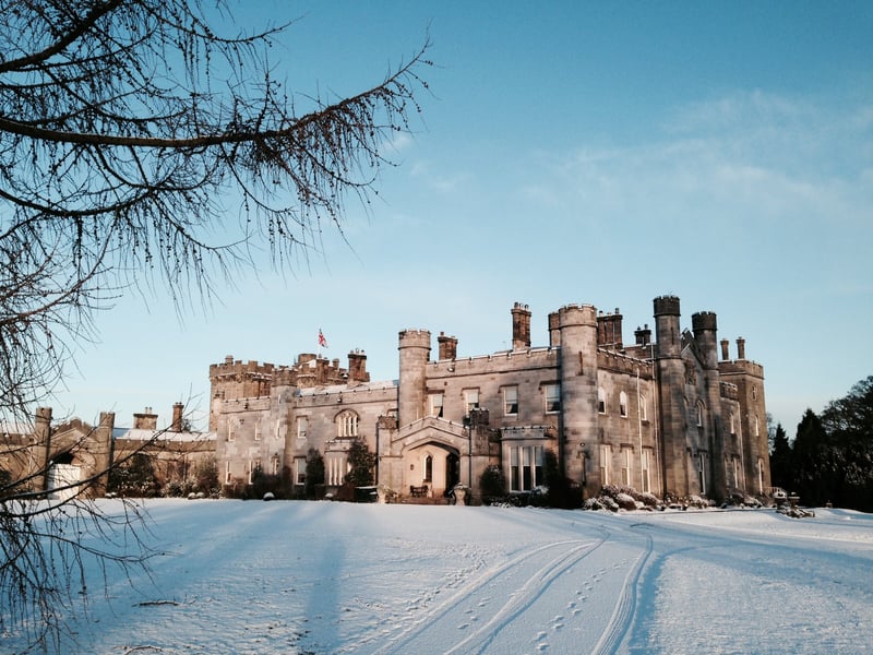 exterior of a castle wedding venue in Scotland covered in snow.