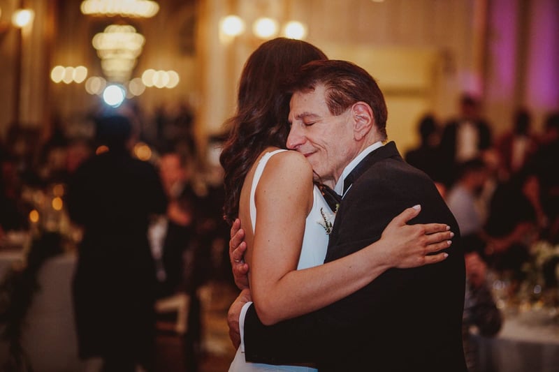 a bride and her father dance slowly to a father-daughter dance song.