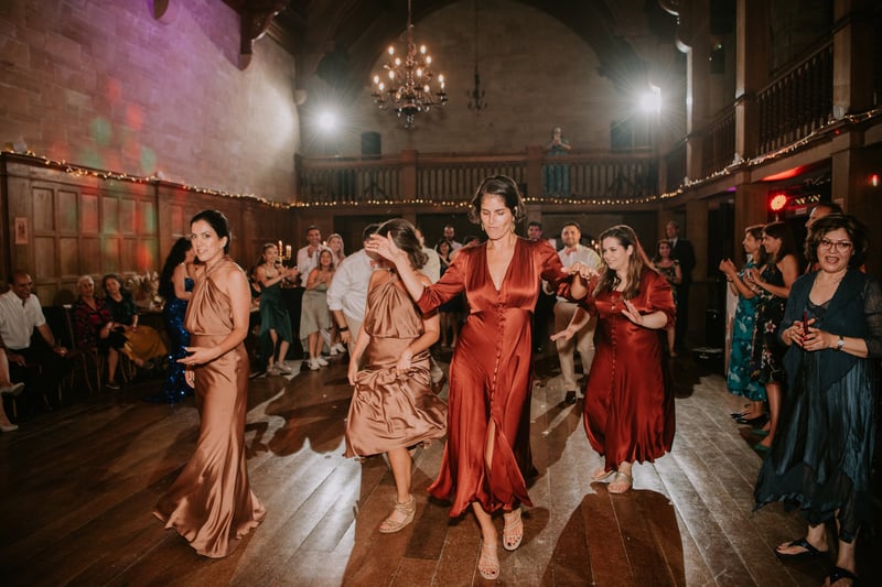a group of guests dance at a winter wedding reception.