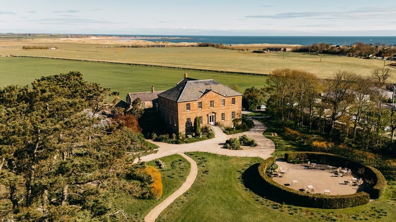 Aerial view of Newton Hall wedding venue with the Northumberland coast behind