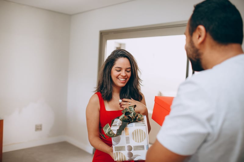 a woman and a man swapping anniversary gifts