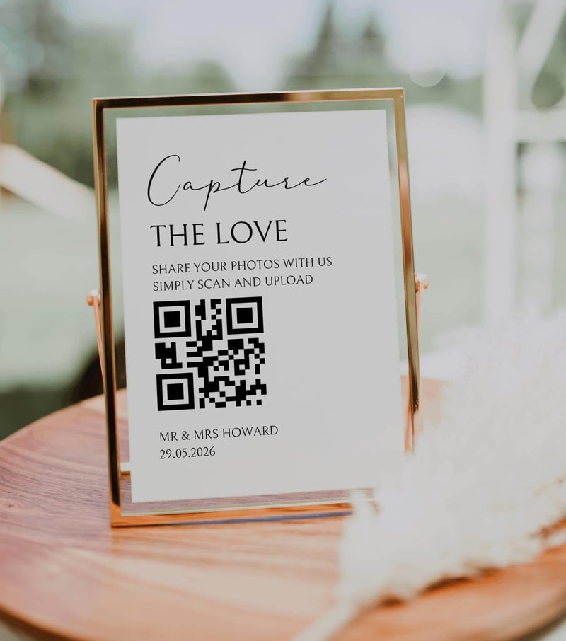 a QR code wedding sign in a gold frame on a wooden table.