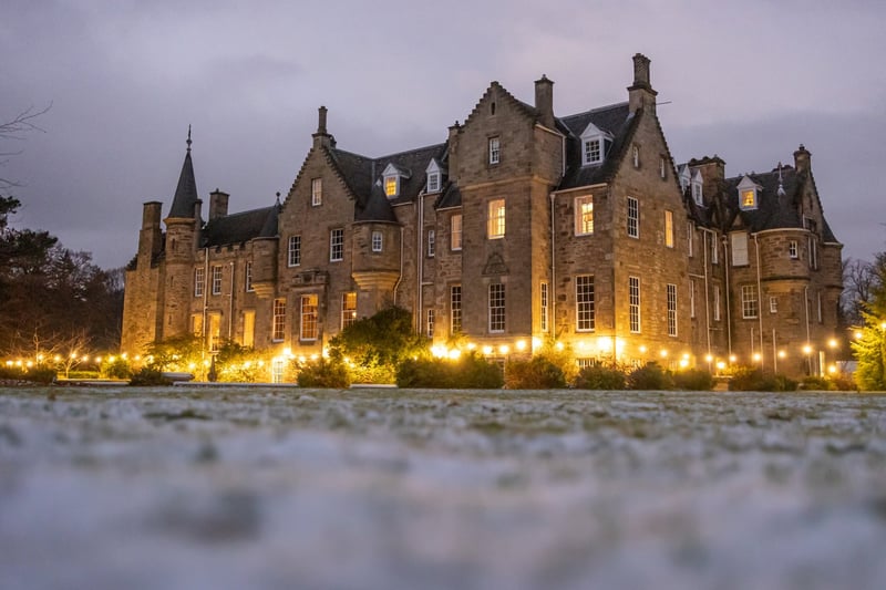 exterior of a country mansion house in Scotland in the evening with a dusting of snow on the ground.