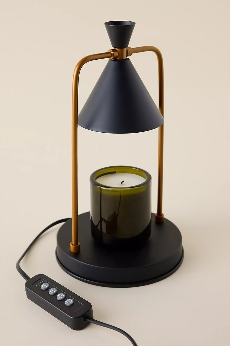 a sleek black candle lamp warmer made from black ceramic and copper.