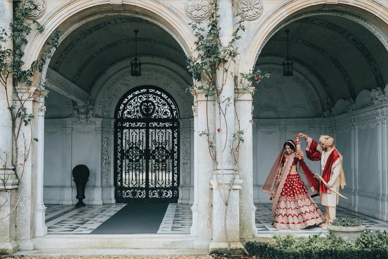 a groom twirling his Hindu bride underneath an arch.