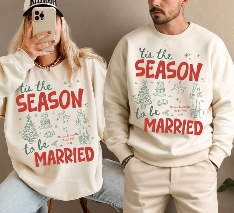 a man and woman wearing matching Christmas sweaters that read, 'Tis the season to be married'.