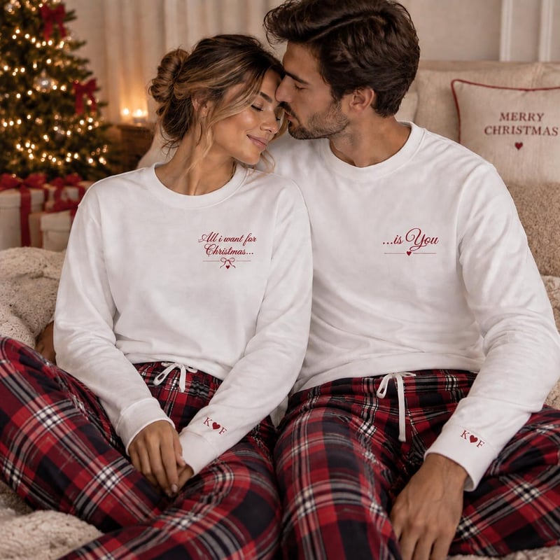 a man and woman on a sofa wearing matching pyjamas.