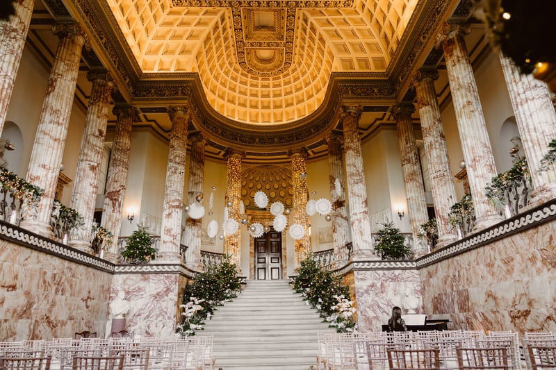interior of a marble hall set up for a winter wedding ceremony on the steps.