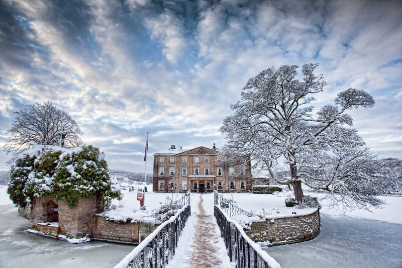 exterior of a hotel wedding venue surrounded by a lake in snow.