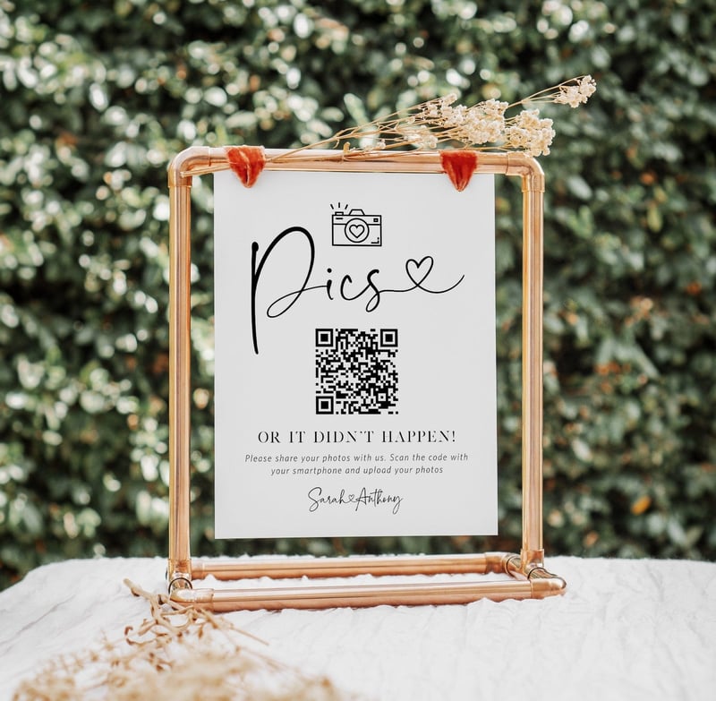 a wedding qr code sign in a gold hanging frame on a table outside.