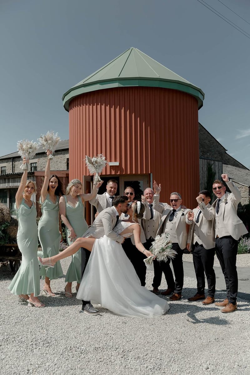 Couple celebrating with their wedding party outside the red silo at Runa Farm