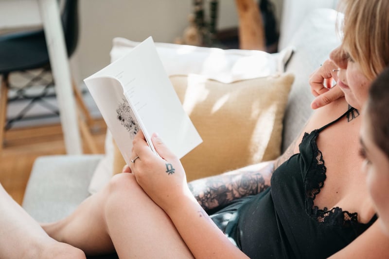 two women sitting close reading a wedding card on the sofa.