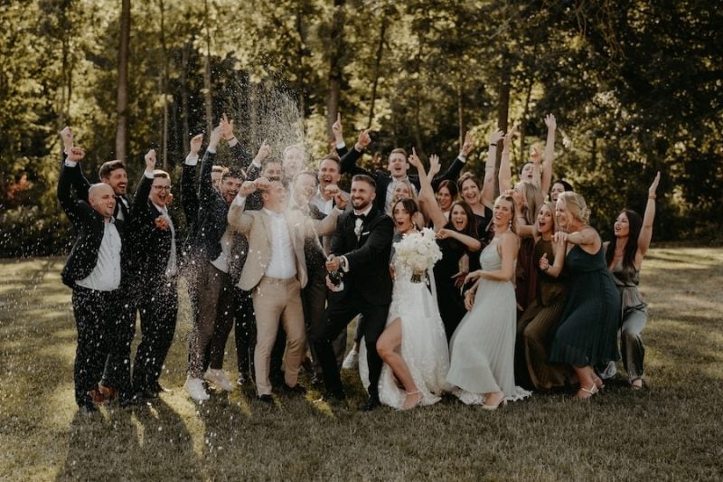 Hochzeitsgesellschaft im Freien bei einer Champagnerdusche