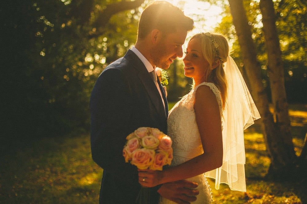 Bridebook.co.uk- bride and groom hugging with the sun shining