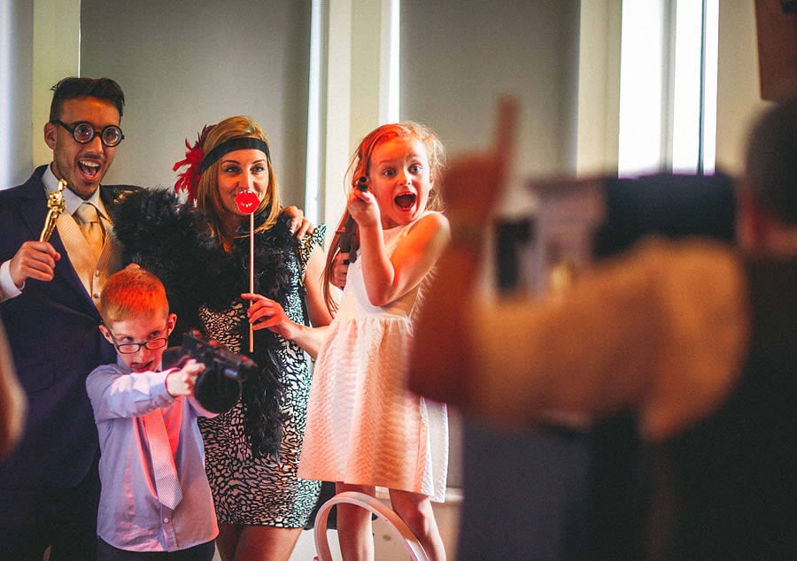 Bridebook.co.uk- wedding guests posing for the photographer with props