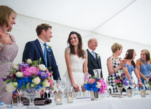 Bridebook.co.uk- bride groom and wedding party standing up at the top table