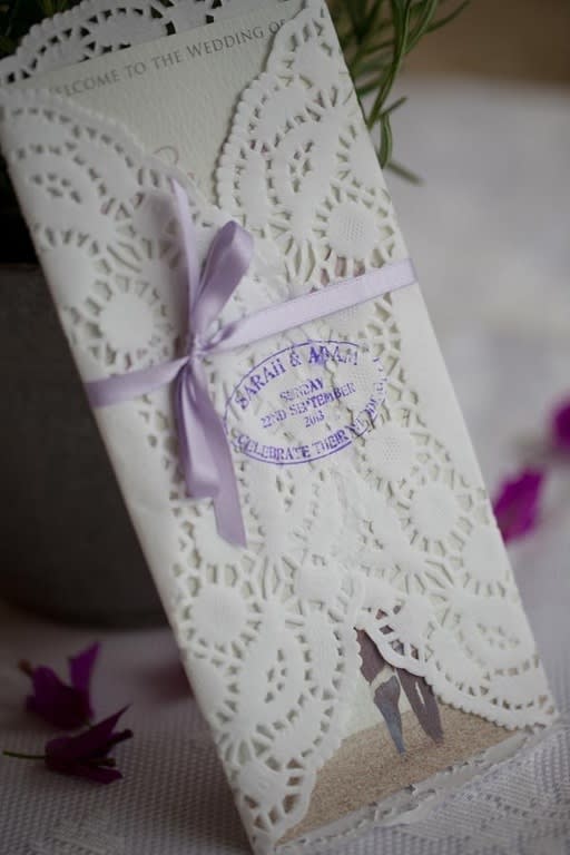 Bridebook.co.uk- laser cut wedding invitation tied with purple ribbon