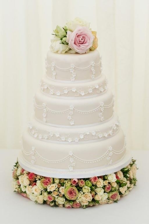 Bridebook.co.uk- five tier white wedding cake topped up with roses