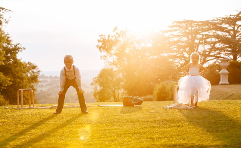 Bridebook.co.uk- flower girl and ring bearer playing in the sun