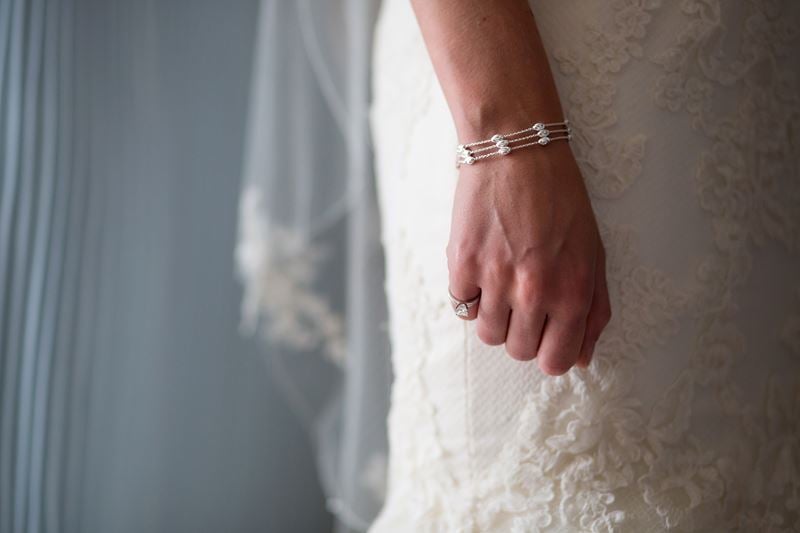 Bridebook.co.uk- bride wearing a ring and a pearl bracelet