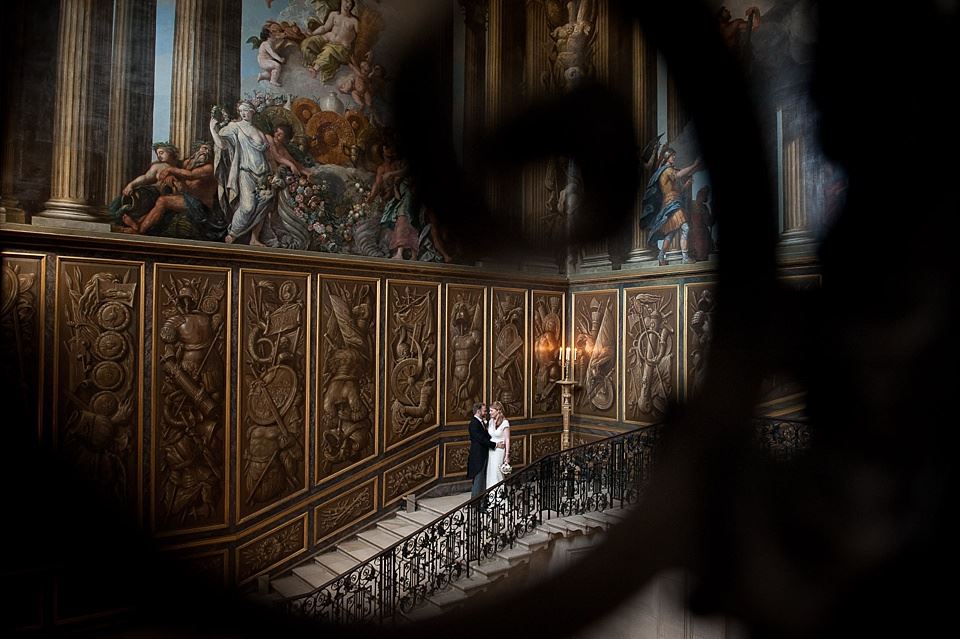 Bridebook.co.uk- groom hugging bride on grand staircase