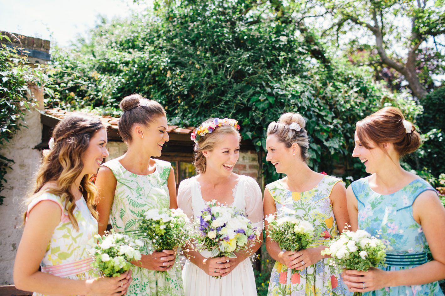 Bridebook.co.uk- bride and bridesmaids holding bouquets and smiling