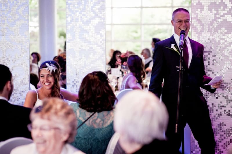 Bridebook.com - father giving speech as bride smiles