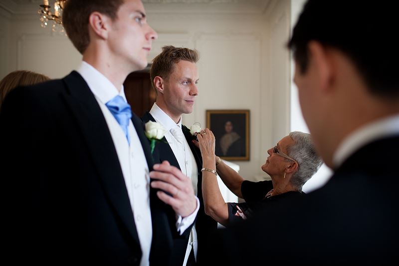 Bridebook.co.uk- groom and usher having their buttonnaires adjusted