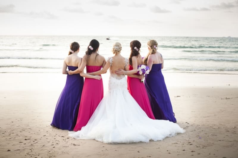 Bridebook.co.uk- bride and bridesmaids against the sea