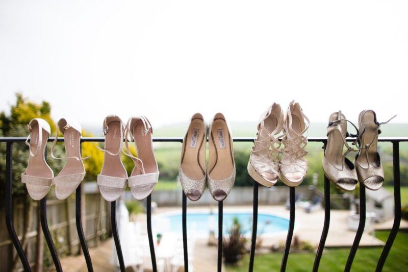 Bridebook.co.uk- bride and bridesmaid shoes balanced on a balcony rail