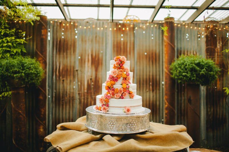 Bridebook.co.uk White Buttercream wedding cake with orange and fuschia flower decoration