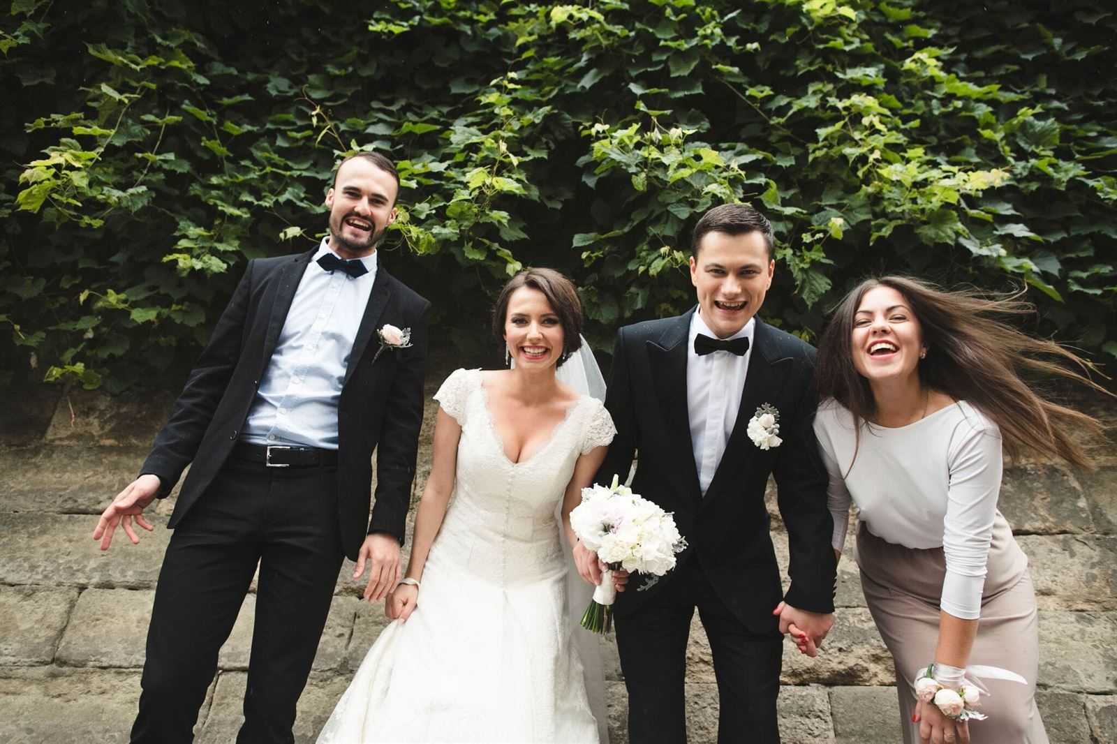Braut und Bräutigam lachen mit Gästen