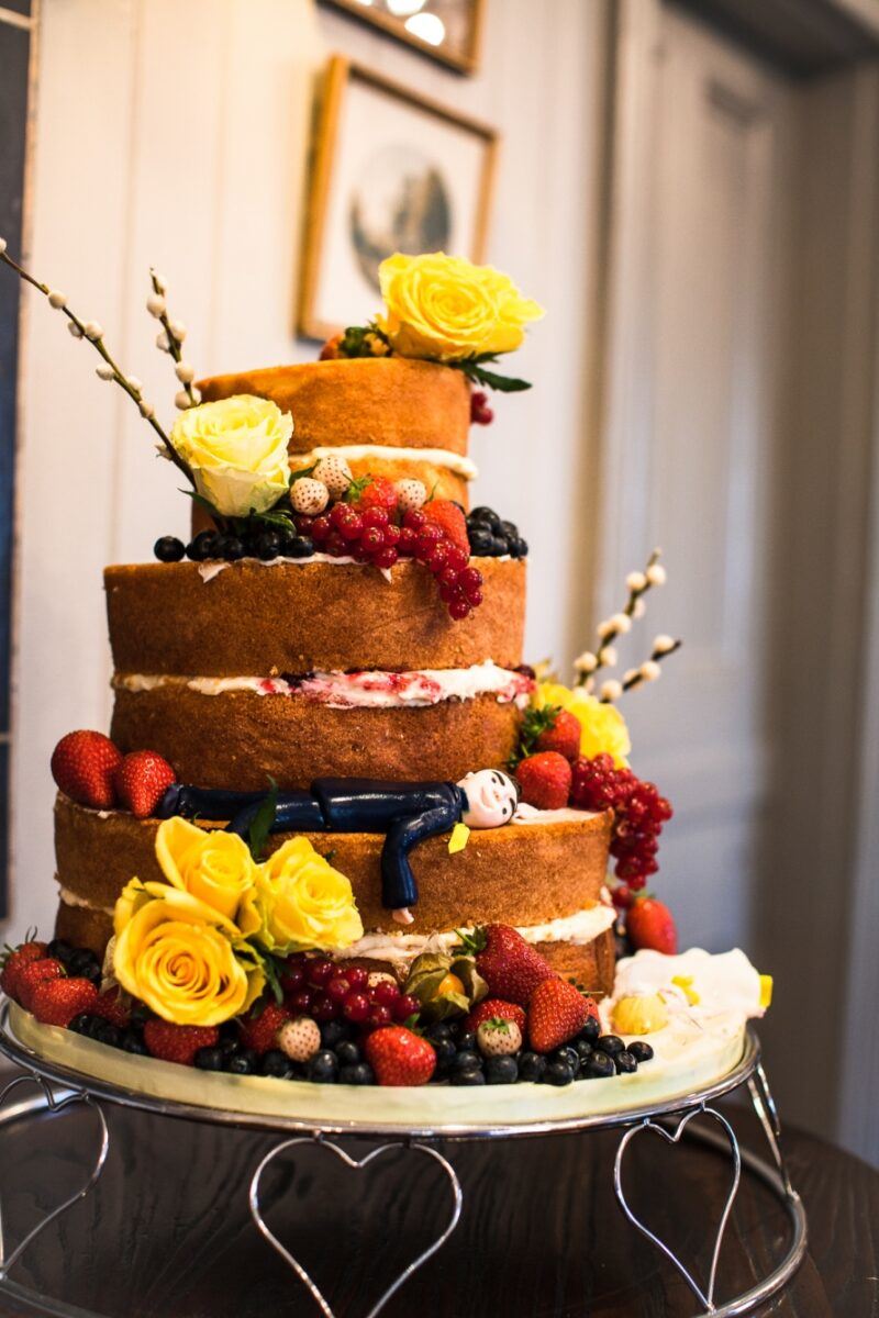 Bridebook.co.uk- naked cake decorated with yellow roses and berries