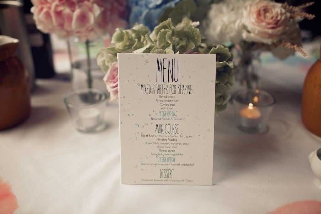 Bridebook.co.uk- Wedding menu propped up on some flowers