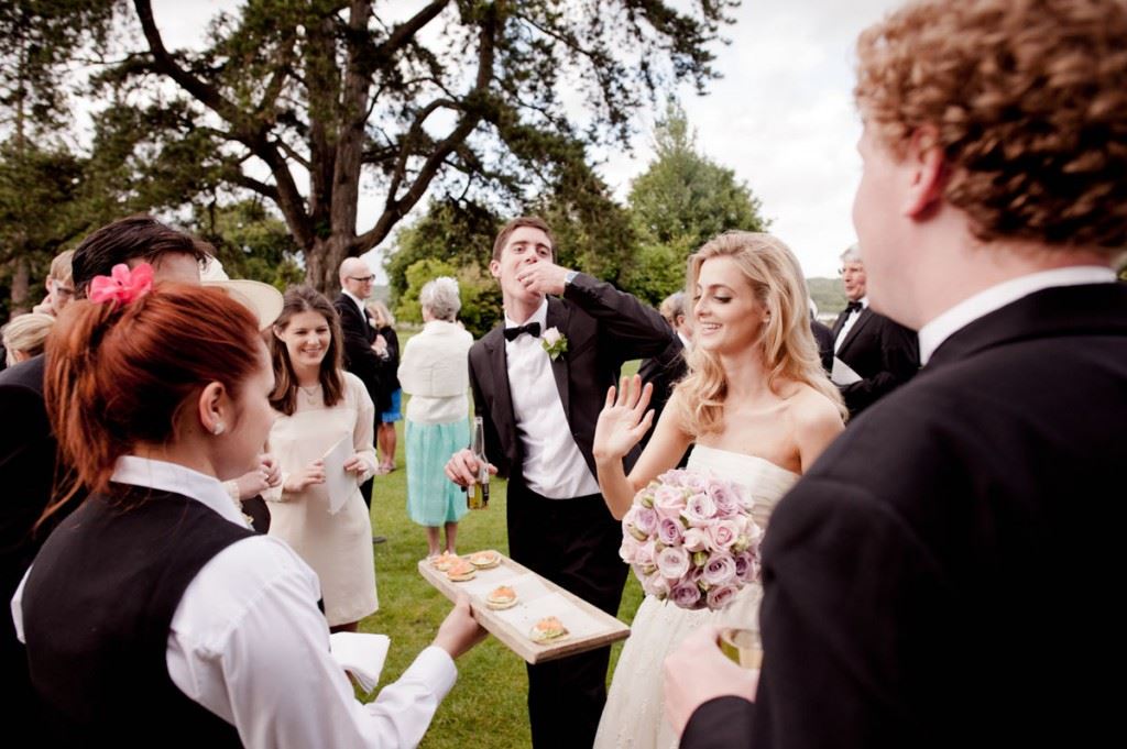 Bridebook.co.uk- bride and groom having canapes