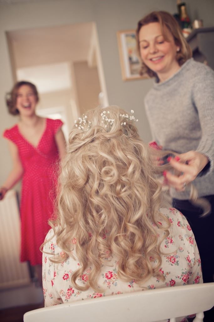 Bridebook.co.uk- bride having her hair curled and decorated with flowers