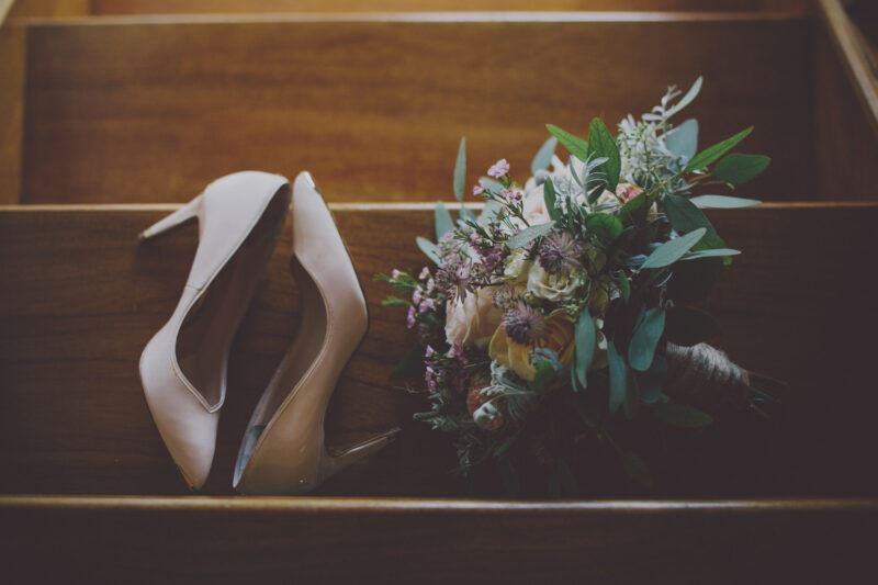 Bridebook.co.uk- wedding shoes and bouquet lying on stairs
