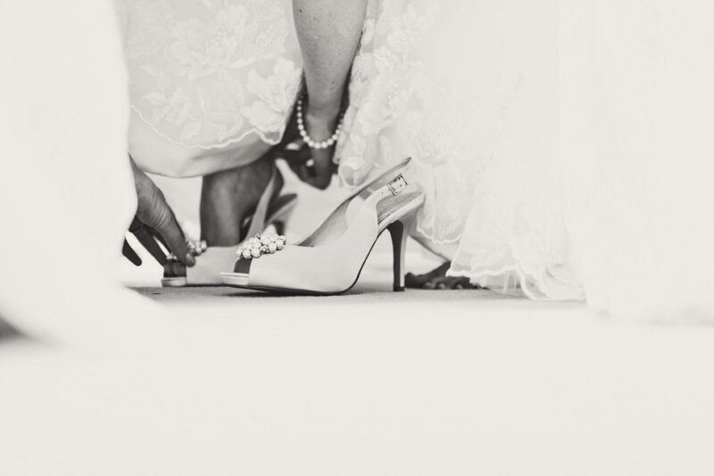 Bridebook.co.uk- bride being helped into her wedding shoes