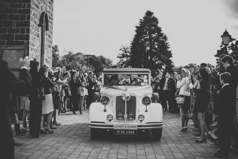 Bridebook.co.uk- bride and groom leaving ceremony in vintage car
