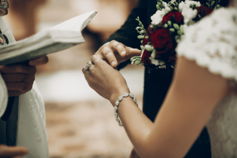 Bride and groom exchanging vows at the altar with a priest