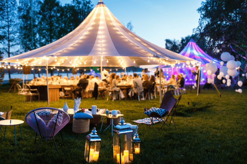 Wedding marquee at night with beautiful rainbow lights and lanterns