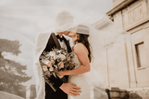 Bride and groom embracing under the bride's veil
