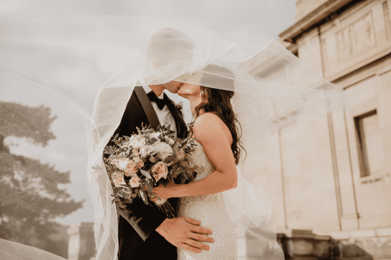 Bride and groom embracing under the bride's veil