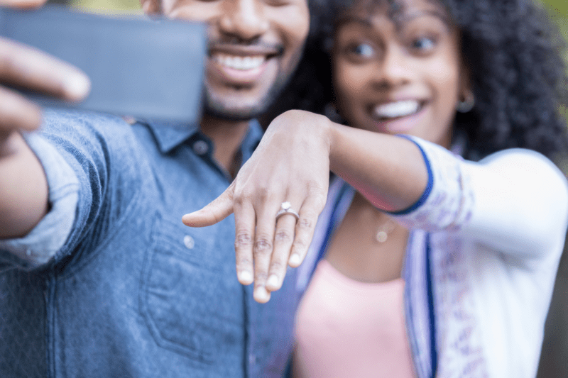 Couple sharing their engagement and bride's engagement ring