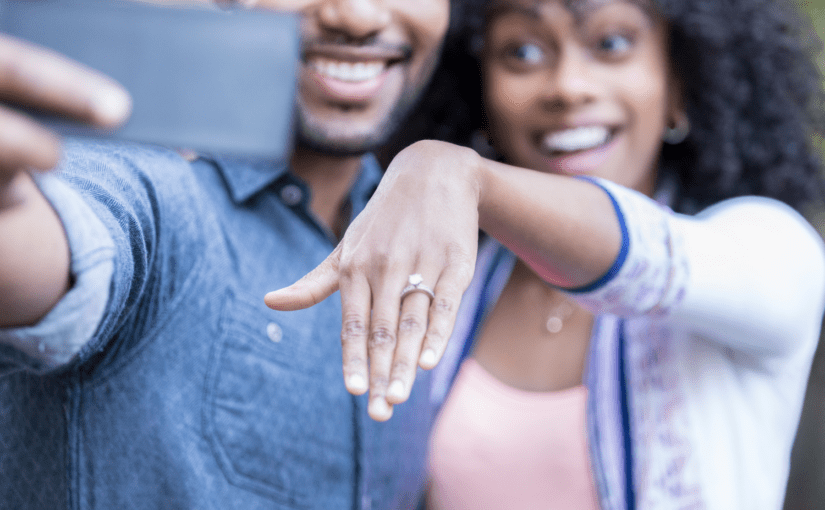 Couple sharing their engagement and bride's engagement ring