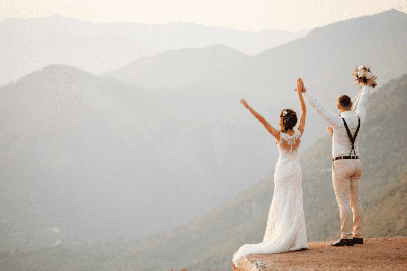 Bride and groom standing on an amazing mountaintop