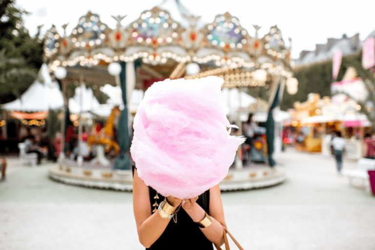 Woman at a fairground holding candyfloss