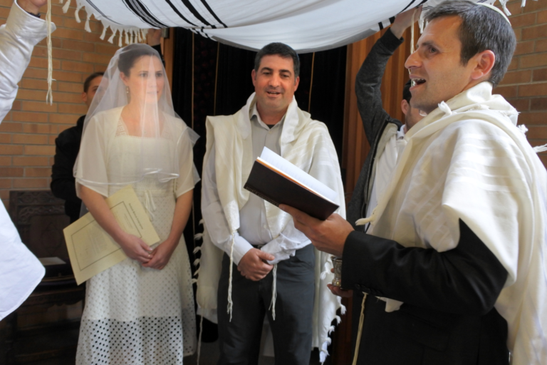 Traditional Jewish wedding couple with rabbi