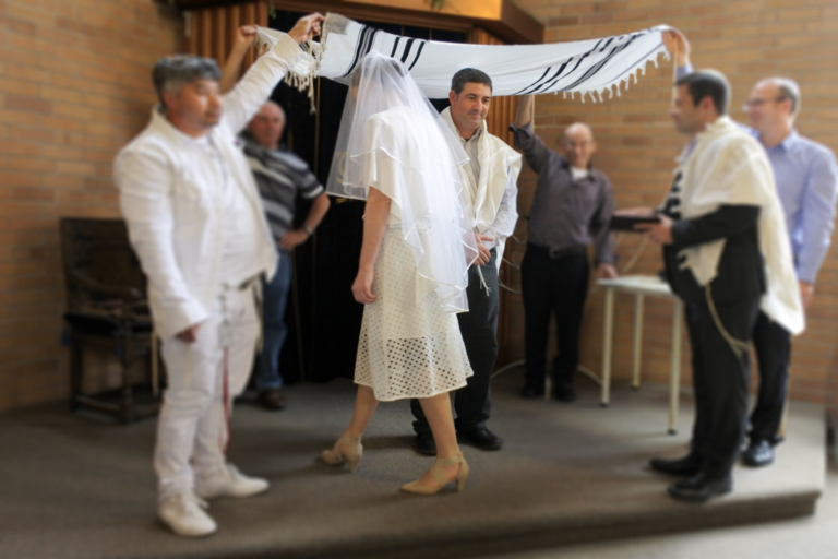 Traditional Jewish wedding couple going under the chuppah